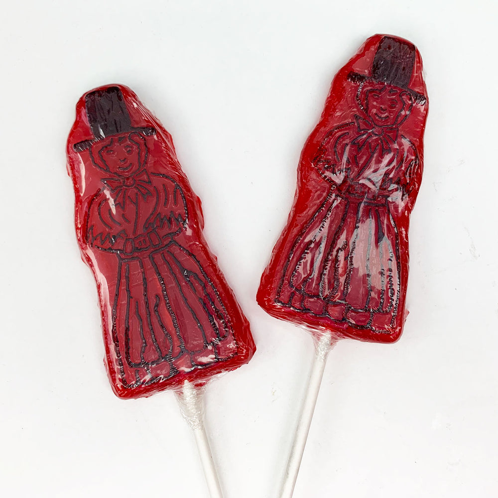 Fruit flavoured hard rock lollipop in bright red with a black Welsh lady outline