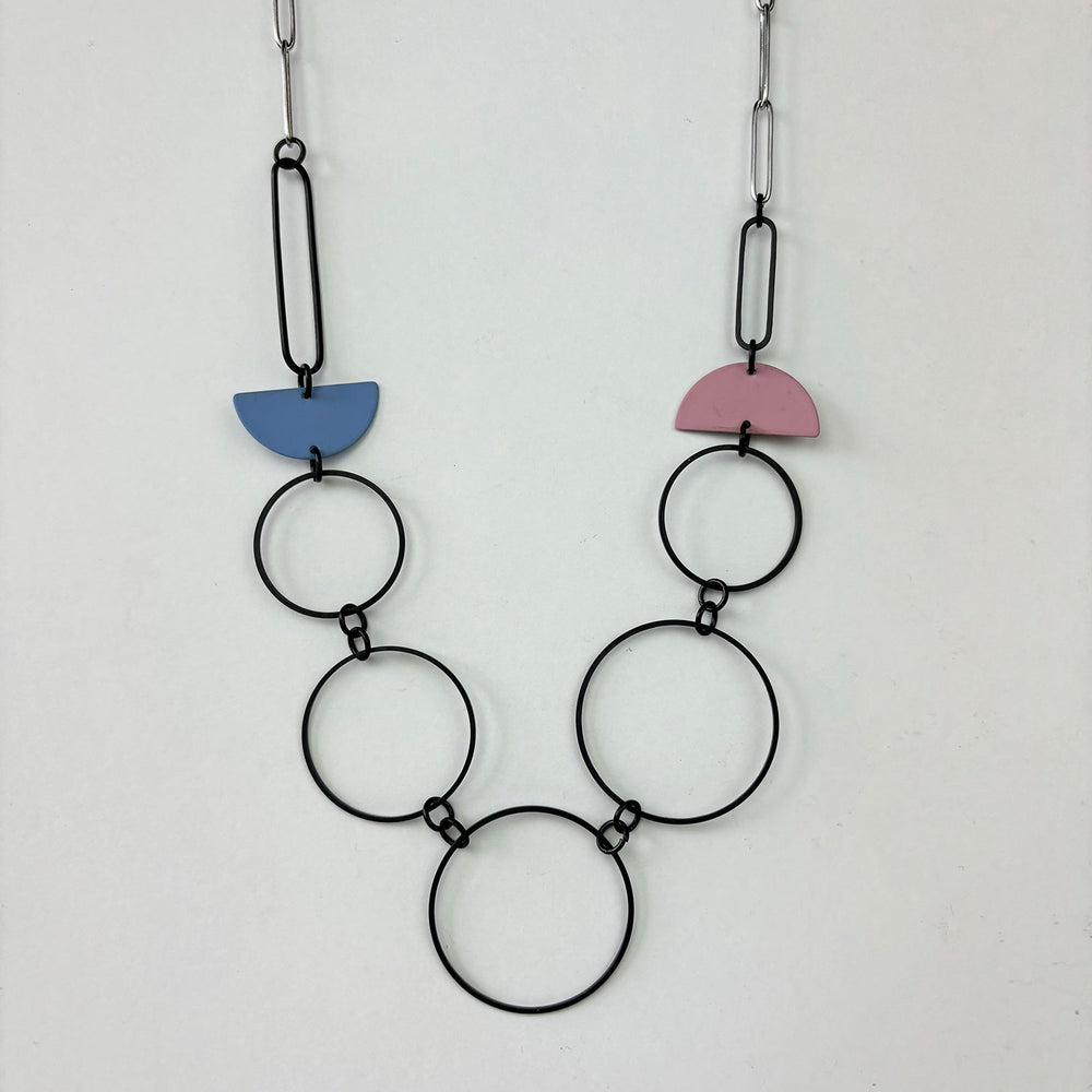 Handmade statement necklace by Deryn featuring black rings and coloured semi circles.