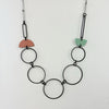 Handmade statement necklace by Deryn featuring black rings and coloured semi circles.