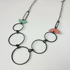 Handmade statement necklace by Deryn featuring black rings and coloured semi circles.