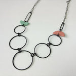 Handmade statement necklace by Deryn featuring black rings and coloured semi circles.