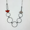 Handmade statement necklace by Deryn featuring black rings and coloured semi circles.