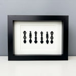 Hand painted Welsh love spoons mounted in a black box frame.