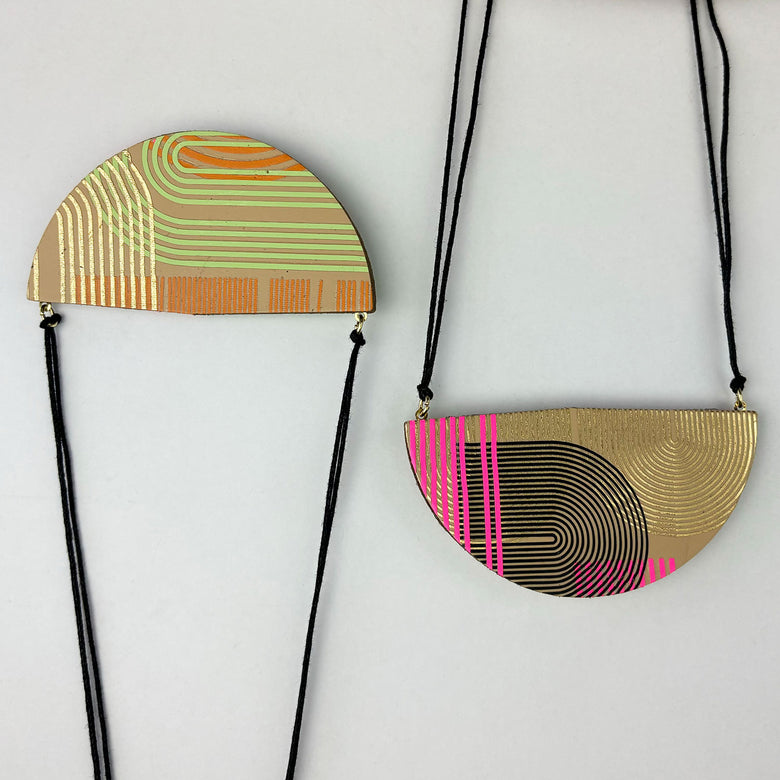 Handmade large semi circle pendant made from double sided reclaimed leather in a geometric arches pattern on black cord