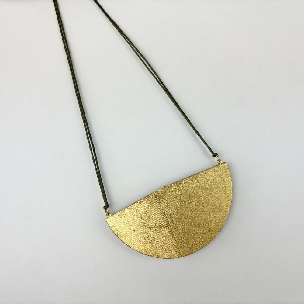 Handmade large semi circle pendant made from gold double sided reclaimed leather on a light green cord.