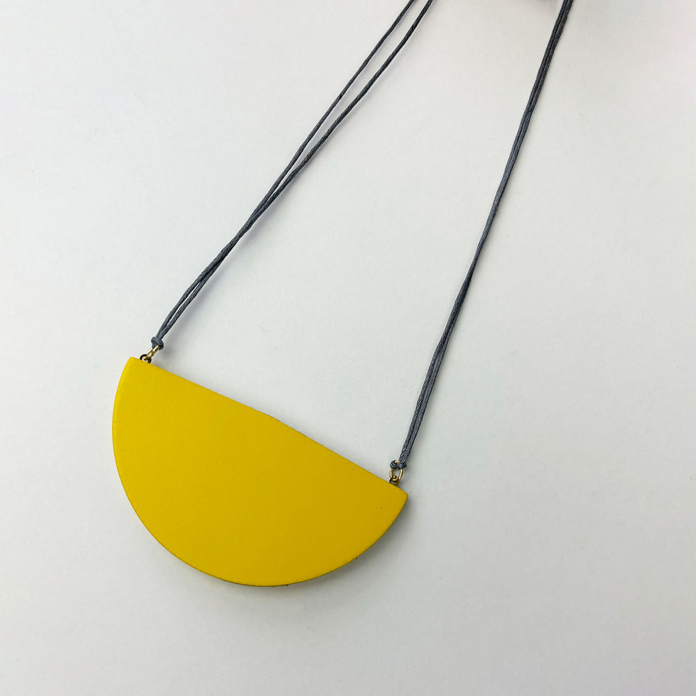 Handmade large semi circle pendant made from yellow double sided reclaimed leather on a light grey cord.