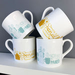 Mustard and duck egg blue china mugs featuring the word paned