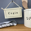 Cream enamel Welsh hanging kitchen sign featuring the word Cegin