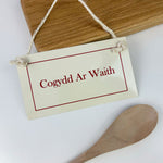 Cream enamel sign featuring the words 'chef at work' in Welsh - Cogydd ar waith