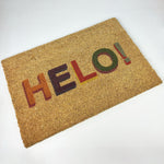 Coir door mat featuring the word 'hello' in Welsh in mulitcoloured letters.