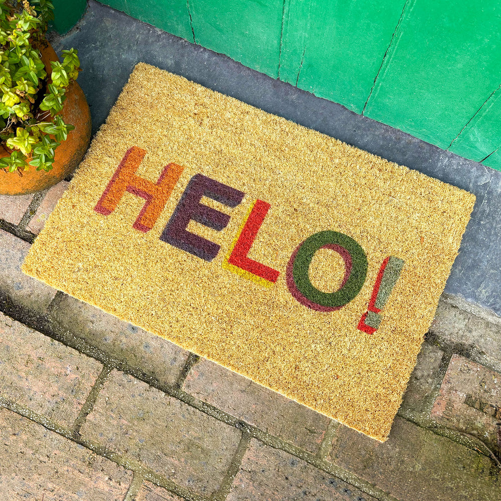 Coir door mat featuring the word 'hello' in Welsh in mulitcoloured letters.