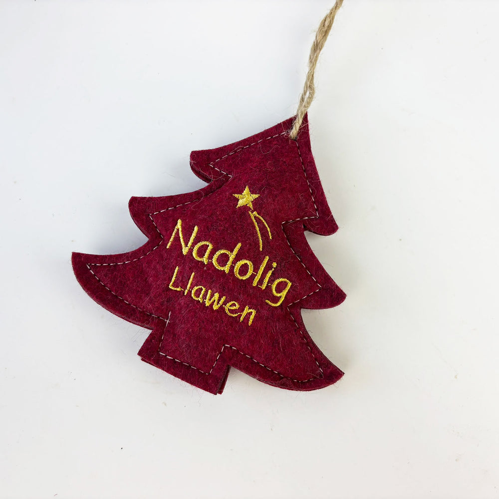 Red Christmas tree-shaped ornament with 'Nadolig Llawen' text on a white background