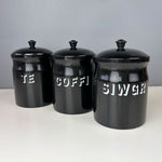 Black enamel kitchen canisters featuring the words tea, coffee sugar in Welsh