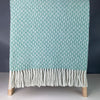 Welsh wool throw in a sea green diamond design with fringing