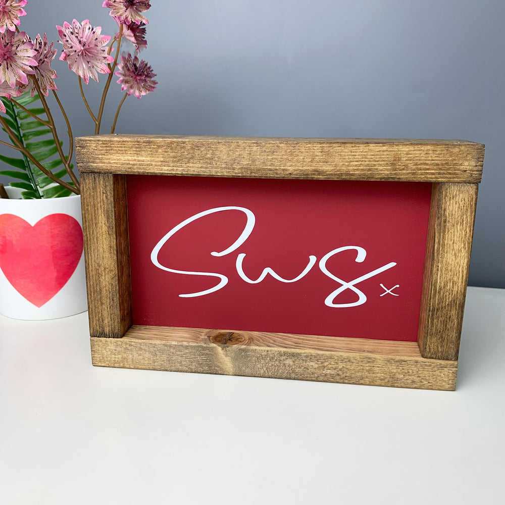 welsh art of the word 'kiss' in Welsh, contained in a handmade wooden frame